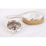 An Edwardian silver oval two-handled sugar bowl of Georgian design, a silver backed hairbrush, 2.5oz