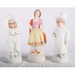 A pair of 19th Century continental porcelain figures of children in winter coats, 7" high, and a