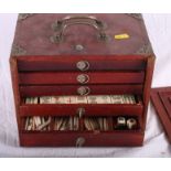 An early 20th Century bone and bamboo mah-jongg set, in wooden case fitted five drawers