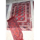 A Bokhara mat decorated eight guls, 48" x 32" approx, and a smaller similar mat, 29" x 12" approx