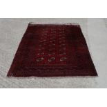 A Bokhara rug decorated three rows of guls in traditional shades, 76" x 52" approx