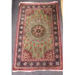 A Persian silk pile rug with all-over radiant design on a green ground and multi-bordered in