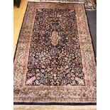 A Persian design rug with all-over floral and scroll design on a dark blue ground, 77" x 48" approx