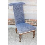 A 19th Century prie dieu chair, upholstered in a blue scroll patterned fabric, on turned supports