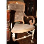 An early 20th Century oak and cane seat and back nursing chair, on turned and stretchered supports