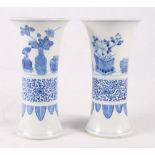 A pair of Chinese blue and white trumpet vases with plants and flowers in pots and containers