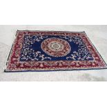 A Tabriz design rug decorated circular medallion and floral scroll spandrels on a dark blue ground