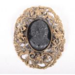 A 19th Century carved jet cameo bust of a young female in later gilt metal floral and scrolled