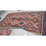 A kilim rug decorated three rows of stepped lozenges on a red ground