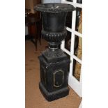 A black painted cast iron garden urn on cement base, 49" high