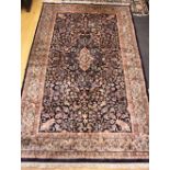 A Persian design rug with all-over floral and scroll design on a dark blue ground, 77" x 48" approx