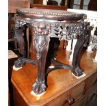 An oriental circular carved hardwood vase stand, top inset marble panel, on ball and claw