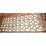 A modern knitted rug decorated three rows of triangles on a cream ground, 98" x 50"