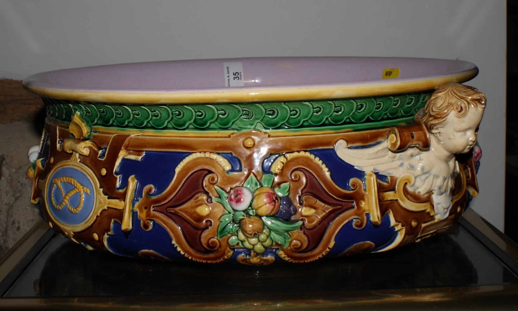 A mid 19th Century Renaissance revival majolica bowl with cherub head handles and relief decoration,