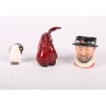 A Royal Doulton flambe decorated model of a rabbit, a miniature Doulton Beefeater character jug