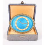 An early 20th Century travel clock with blue enamelled dial, in fitted case, 3 1/4" high