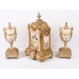 A late 19th Century French gilt metal and porcelain panel clock three-piece garniture with bird