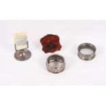 Two silver napkin rings, a silver and tortoiseshell letter clip and a perpetual calendar on silver