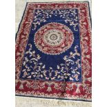 A Tabriz design rug decorated circular medallion and floral scroll spandrels on a dark blue ground