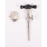 A silver vesta case engraved foliate scrolls and a silver plated champagne tap with ebonised handle