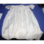 A baby's silk christening gown, a whitework embroidered linen bedcover or tablecloth and other