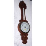 A Victorian aneroid barometer and thermometer in carved wooden case