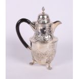 A Victorian silver hot water jug with embossed floral and swag decoration and ebonised handle, on