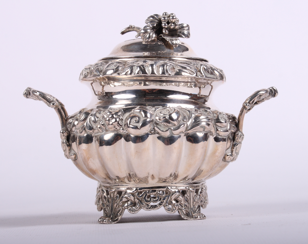 A continental silver two-handled pot and cover with embossed foliate decoration and cast scrolled