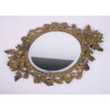 A 19th Century gilt brass openwork framed oval wall mirror with lion crest, 17 1/2" wide