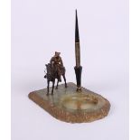 A cold painted bronze figure of a mounted cowboy on onyx desk inkstand base, (horse tail missing)