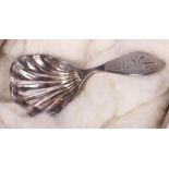 A Scottish silver scallop bowl caddy spoon by J Ritchie, retailed by Hamilton & Inches, in