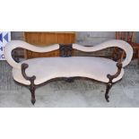 A Victorian carved walnut showframe conversation settee, upholstered in a cream velour, on