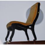 A Victorian nursing chair in ebonised frame, upholstered in a gold velour