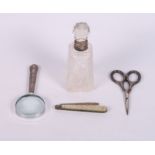 A silver mounted cut glass scent bottle, a silver fruit knife, a silver handled magnifying glass and