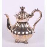 A Georgian silver coffee pot of compressed melon form, raised on four shell cast supports, 30.9oz