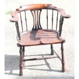 A George III mahogany spindle back elbow chair with saddle seat, on turned and stretchered supports