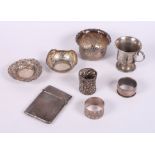 A silver spot hammered card case, two silver napkin rings, a silver christening mug, two pierced