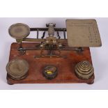 A late 19th Century brass letter balance and weights, on oak base, 10" wide