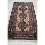 A Persian tribal rug decorated three cruciform medallions on a fawn ground and multi-bordered in