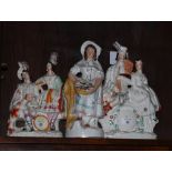 A 19th Century Staffordshire watch group, 13 1/2" high, a similar group, travelling players, 13"