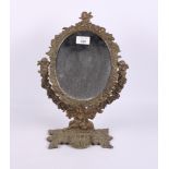 A brass cupid and scroll framed oval swing frame toilet mirror, on shaped base, 16" high