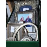 Three silver photograph frames with embossed foliate decoration and a number of silver photograph