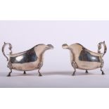 A pair of Walker and Hall silver sauce boats with gadrooned borders and sea scroll handles, raised