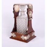 A late Victorian oak and silver mounted single bottle tantalus, fitted two side handles, with a