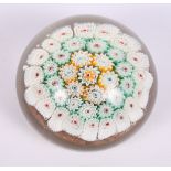 A millefiori paperweight, the canes on an aventurine base, 4" dia