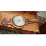 A carved oak cased aneroid barometer and thermometer