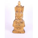 A Far Eastern carved wood and gilt figure of seated winged deity, 14 1/2" high