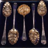 Two matched pairs of Georgian silver and gilt berry spoons with embossed and engraved decoration and