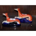 A pair of Staffordshire greyhound shaped inkwells, 4 1/4" high (one restored)