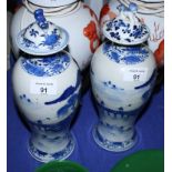 A pair of 19th Century Chinese blue and white baluster-shaped vases and covers decorated